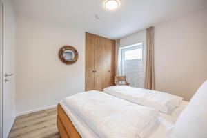 1 Schlafzimmer mit 2 Betten und einem Wandspiegel in der Unterkunft Ferienwohnung Wiking-Koje 5 Schleswig in Schleswig + 34 Fotos