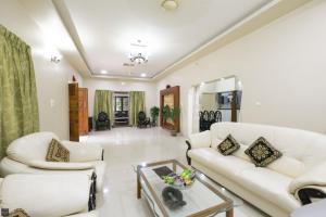 a living room with two white couches and a table at Reunion Ocean Daaffy - Beach House in Udupi