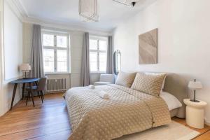 a white bedroom with a bed and a desk at Spacious Apartment on Lively & Vibrant Street in Copenhagen