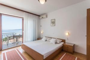 una camera da letto con un letto e una grande finestra di Apartments Vedra a Baška Voda