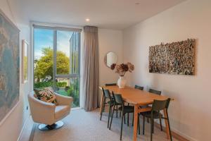 a dining room with a table and chairs and a window at Malthouse Lane City Apartment 4 in Nelson