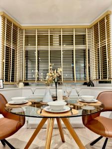 a dining room with a glass table and chairs at Superb Duplex in Hendon in The Hyde