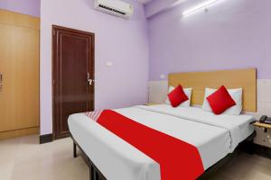HasanganjHotel O SRV Palace的卧室里有一张大床，配有红色枕头