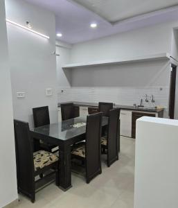 a dining room with a black table and chairs at Satyabhama Home Stay - Opel - Two BHK in Indore +11 photos