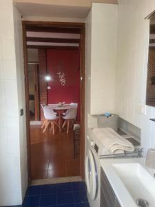 a laundry room with a table and a washing machine at Appartamento Homemade privato a due passi dal centro in Biella