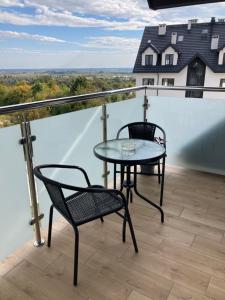 a table and chairs on a balcony with a view at Apartament 7 Wzgórz in Sandomierz