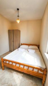 a bedroom with a large bed with white sheets at Oli Kazdağları in Biller