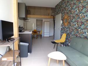 a living room with a couch and a kitchen at L'atypique studio 1 à 3 voyageurs in Bazas
