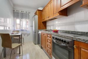 una cucina con mobili in legno e un frigorifero in acciaio inossidabile di Apartamento Romo a Candelaria