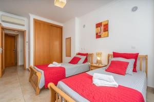two beds in a room with red and white sheets at Palmeiras de jv in Lagos +28 photos