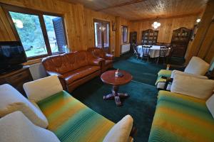 a living room with couches and a television and a table at Casa de vacanta Satic Piatra Craiului La Doi viermi in Satic
