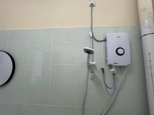 a shower in a bathroom with a soap dispenser on the wall at Lovely Home in Kuala Terengganu in Kuala Terengganu +35 photos