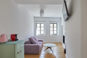 a living room with a purple couch and a table at Clock Tower Arachova in Arachova +20 photos