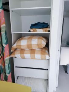 a white closet with two pillows in it at Charmant studio - Terrasse - Parking gratuit in Montpellier