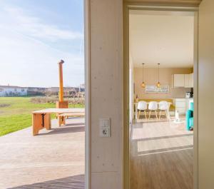 an open door leading to a patio with a table at Cumbuco - Ecohuisjes Terschelling in Midsland