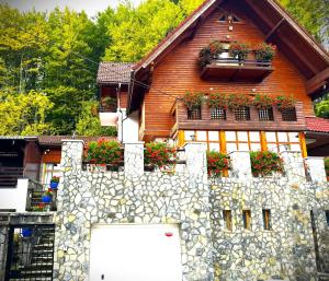 a house with a stone wall and flower boxes on it at ALISIO in Sinaia