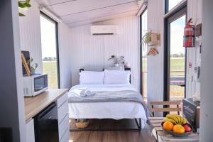 a small bedroom with a bed in a tiny house at The Gums Cottage by Tiny Away in Hallett