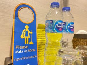 two bottles of water sitting next to a sign at A Plus Deluxe Hotel in Ko Lipe