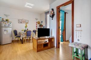a living room with a television and a table with chairs at Los Secretos De San Marcos Seaview in San Marcos
