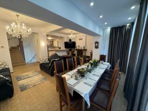 a dining room with a table and chairs and a living room at Villa Alisio Sinaia in Sinaia