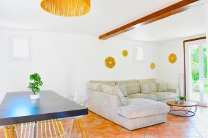 ein Wohnzimmer mit Sofa und Tisch in der Unterkunft Charmante Maison de Ferrières in Ferrières-Haut-Clocher