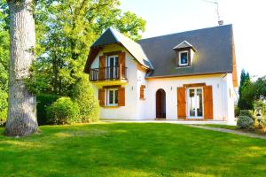 ein weißes Haus mit einem Baum im Hof in der Unterkunft Charmante Maison de Ferrières in Ferrières-Haut-Clocher
