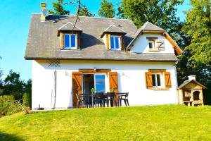 ein kleines weißes Haus auf einem Grashügel in der Unterkunft Charmante Maison de Ferrières in Ferrières-Haut-Clocher