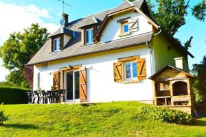 ein kleines weißes Haus auf einem grünen Rasen in der Unterkunft Charmante Maison de Ferrières in Ferrières-Haut-Clocher