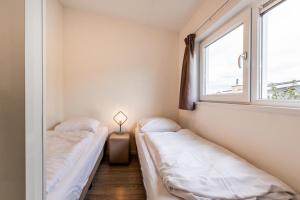 two beds in a room with a window at Biebosch - Garden house in Valkenburg +15 photos