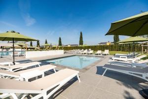 a pool with white lounge chairs and umbrellas at Biebosch - Garden house in Valkenburg