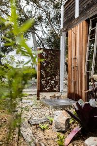 eine offene Tür eines Holzgebäudes mit einer Holztür in der Unterkunft Orion Beach Cottage A - Jervis Bay in Vincentia