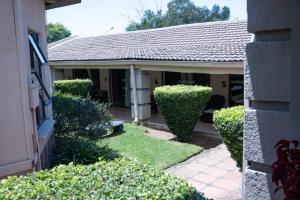 una casa con un giardino con cespugli di fronte di 196 On Victoria Bed & Breakfast a Newcastle