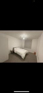 a bedroom with a white bed in a room at Peaceful home in Barking +1 photo