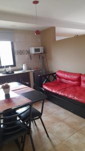 a living room with a red couch and a table at ZUHAUSE in Puerto Iguazú +7 photos