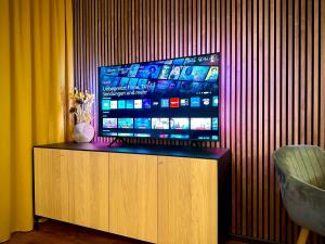 a flat screen tv sitting on top of a wooden cabinet at Pfalz Apartments - modern, stylisch und in Toplage! in Neustadt an der Weinstraße