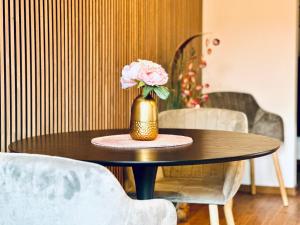 a table with a vase with a flower in it at Pfalz Apartments - modern, stylisch und in Toplage! in Neustadt an der Weinstraße +56 photos