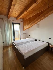 two beds in a room with wooden ceilings at Marconi Deluxe - Attico - Deluxe Apartments Italia in Lido di Jesolo