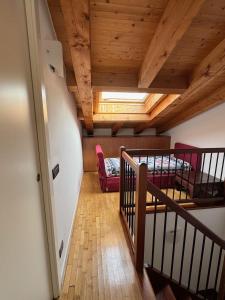a room with wooden ceilings and a staircase with a bed at Marconi Deluxe - Attico - Deluxe Apartments Italia in Lido di Jesolo