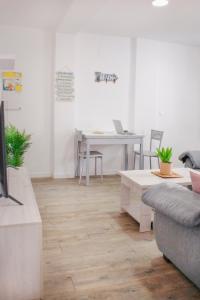 een woonkamer met een tafel, een bank en een bureau bij APARTAMENTO LOS LANCES PLAYA in Tarifa