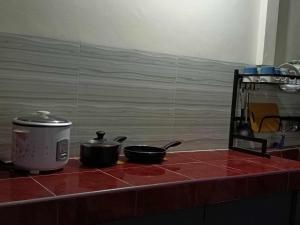 two pots and pans on a counter in a kitchen at A's Guest House in Buaya