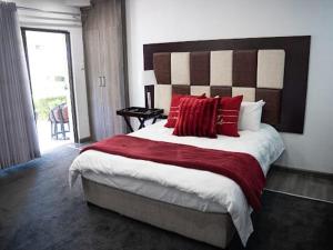 una camera da letto con un letto grande con cuscini rossi di 196 On Victoria Bed & Breakfast a Newcastle Altre 19 foto