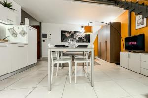 a white dining room table and chairs in a kitchen at Loft Stadio - Parking, Gym & Comfort in Turin