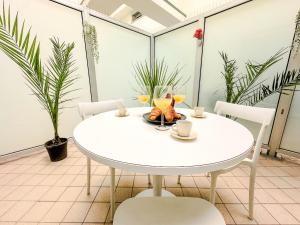 a white table and chairs in a room with plants at Loft Stadio - Parking, Gym & Comfort in Turin