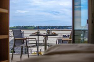 a balcony with a table and chairs and a view of the water at Ferienwohnung Wiking-Koje 7 Schleswig in Schleswig