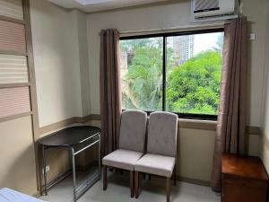 a room with two chairs and a large window at St Martin Village unit 2B in Mandaue City