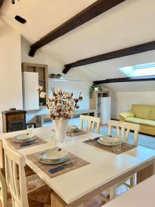 ein Esstisch mit einer Vase mit Blumen darauf in der Unterkunft Casa Sopra in Castel di Sangro