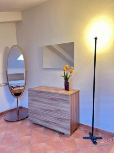 ein Spiegel und eine Kommode mit einer Blumenvase darauf in der Unterkunft Casa Sopra in Castel di Sangro + 4 Fotos