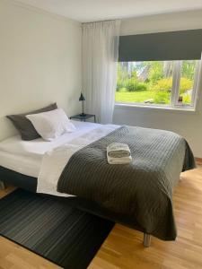 a bedroom with a large bed with a window at Lys og koselig leilighet nært flyplass og tur terreng in Tromsø