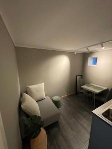 a living room with a couch and a table at Lys og koselig leilighet nært flyplass og tur terreng in Tromsø +26 photos