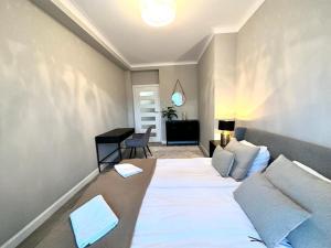a room with a bed and a desk in it at Apartament nad Łyną by RENT4YOU in Olsztyn +8 photos